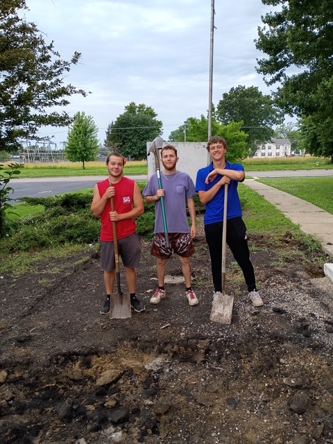 Three Eta Mu brothers with shovels during the 2026 work weekend